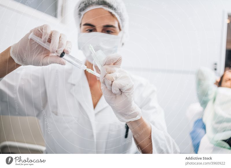 Arzt, der eine mit Anästhesieflüssigkeit gefüllte Nadel in einem Krankenhaus abdeckt crotochisch Aktion Flasche Verschlussdeckel Container Deckung Kur