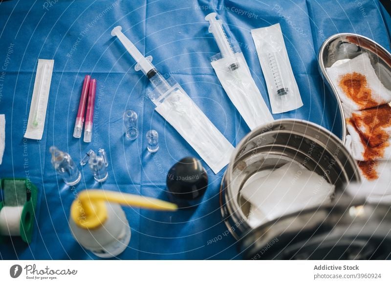 OP-Tisch mit blauem Tischtuch mit Nadeln, Jodgaze, Anästhetikum und einem Metalltopf crotochisch Anästhesie Pause Stoff Voraussetzung Container Kur Diagnostik