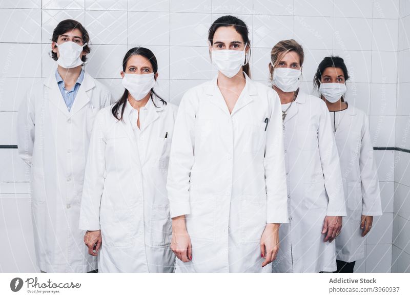 Eine Gruppe von Ärzten mit einer Maske auf dem Gesicht und Uniform aufstehen in einem Krankenhaus crotochisch Überprüfung Klinik Mantel Berater Coronavirus