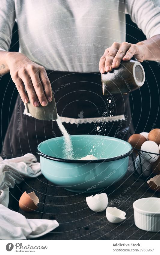 Crop-Frau, die Zutaten für Teig in einer Schüssel mischt Koch Teigwaren mischen Bestandteil eingießen Schalen & Schüsseln Zucker Mehl Küche hinzufügen
