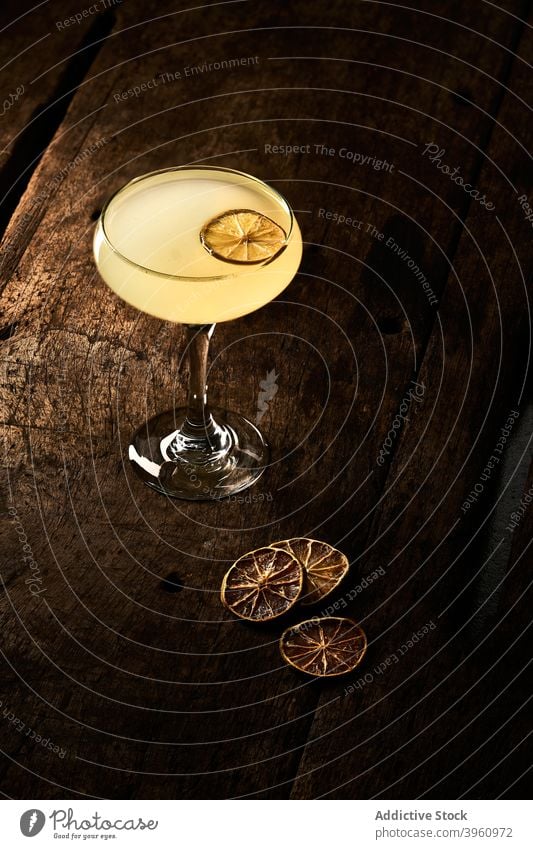 Alkohol-Cocktail auf Holztisch gelb orange Scheibe trinken Garnierung trocknen getrocknet Getränk Glas Schnaps geschmackvoll Tisch lecker Erfrischung