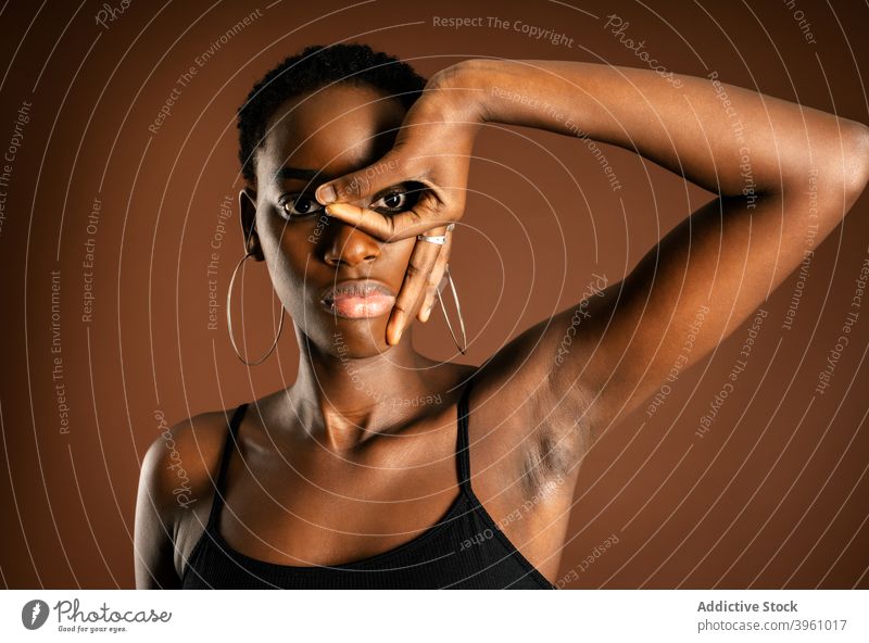 Schwarze Frau macht Maske Geste Mundschutz gestikulieren Stil Auge modern Vorschein jung Model Kurze Haare Zeichen Ohrringe Mysterium Persönlichkeit cool