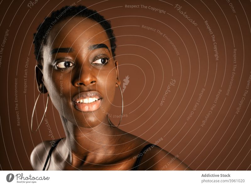 Schlankes afroamerikanisches Modell stehend auf braunem Hintergrund Frau schlank Stil Anmut lässig Outfit Kurze Haare schlanke ethnisch schwarz Afroamerikaner