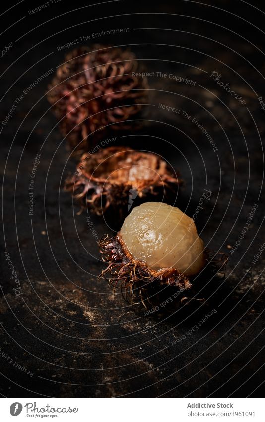 Makro-Ansicht von Rambutan auf dunklen rustikalen hölzernen Hintergrund Dessert Frucht Ackerbau Asien asiatisch lecker Nahaufnahme schließen Essen exotisch