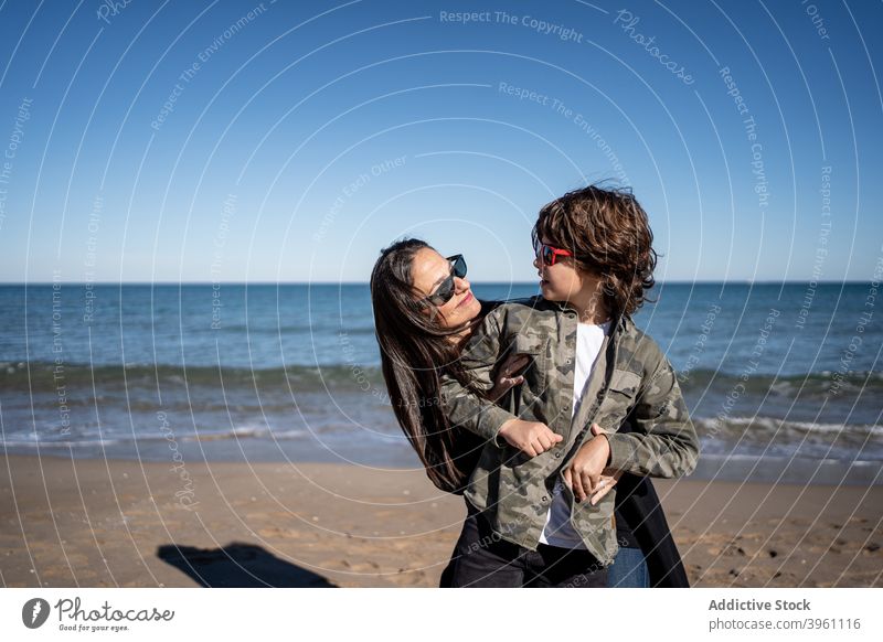 Mutter, die ihren Sohn am Strand im Winter umarmt Junge Kinder Familie Mittelmeer mediterrane Kultur authentisch aktiv Pause Küste kalt Konzept genießen Spaß