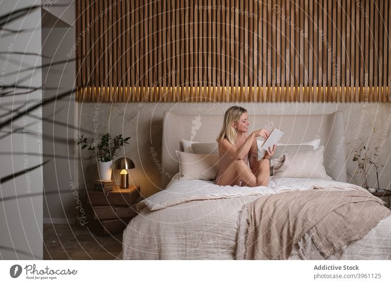Frau liest Buch auf dem Bett am Abend lesen genießen Etage Nachtwäsche Schlafzimmer heimwärts sitzen interessant Roman Komfort Belletristik gemütlich Wochenende