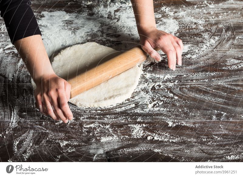 Frau rollt Teig auf dem Tisch Teigwaren rollen Nudelholz Brot Bäcker Lebensmittel vorbereiten Mehl Bäckerei Hand Küche kulinarisch Koch Gebäck Küchenchef