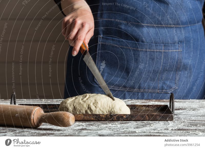 Bäcker schneidet Teig für Brot Teigwaren geschnitten Messer Lebensmittel vorbereiten Mehl Bäckerei Kunstgewerbler Küche kulinarisch Frau Koch Gebäck Küchenchef