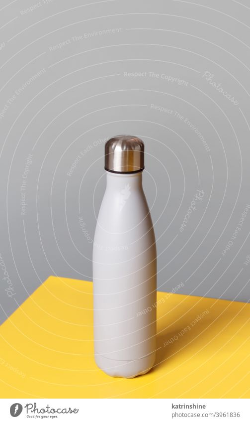 Graue wiederverwendbare Stahlflasche auf grauem und gelbem Hintergrund Flasche Monochrom Attrappe isoliert ökologisch Wasser Thermo Leichtmetall blanko
