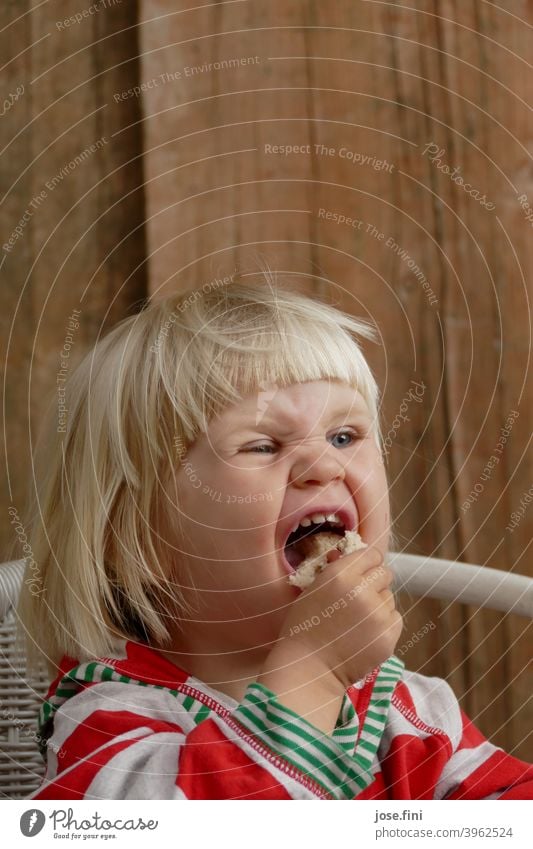 Mh lecker Brot Mädchen süß Freude Grimasse Verschmitzt ponyfrisur Porträt blond kleines Mädchen Kind Kindheit niedlich frech Essen genießen aufgeregt fasziniert