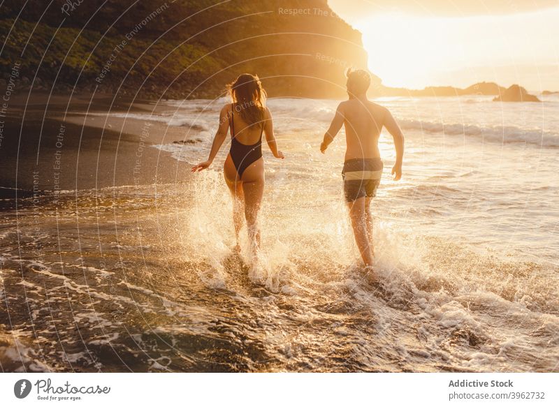 Romantisches Paar zu Fuß auf schäumenden Meer Wellen MEER Sonnenuntergang winken romantisch Liebe Strand Zusammensein Glück Spaß haben Händchenhalten Küste