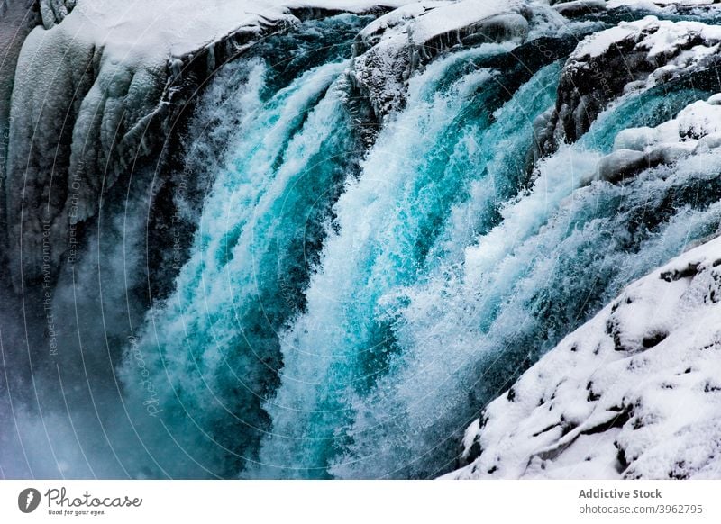 Erstaunlicher Wasserfall in gebirgigem Terrain im Winter fließen strömen reißend Schnee Berge u. Gebirge felsig Landschaft Island Natur malerisch Umwelt kalt