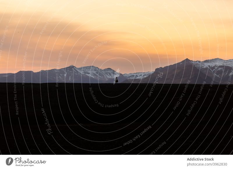 Reisende stehen in den Bergen bei Sonnenuntergang Reisender Silhouette Berge u. Gebirge Winter Himmel Hochland bewundern Landschaft Island Entdecker Gelände