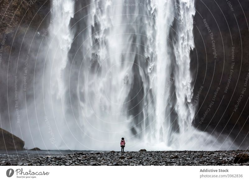 Explorer stehend in der Nähe Wasserfall am sonnigen Tag Reisender Berge u. Gebirge Urlaub Landschaft erstaunlich fließen strömen Tourismus Island erkunden