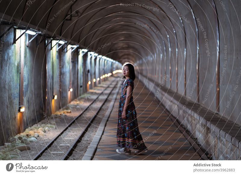 Ethnische Frau steht in einem schäbigen gewölbten Tunnel Stollen Torbogen alt Kleid Tourist Wahrzeichen Ausflugsziel ethnisch asiatisch alter Baiji-Tunnel