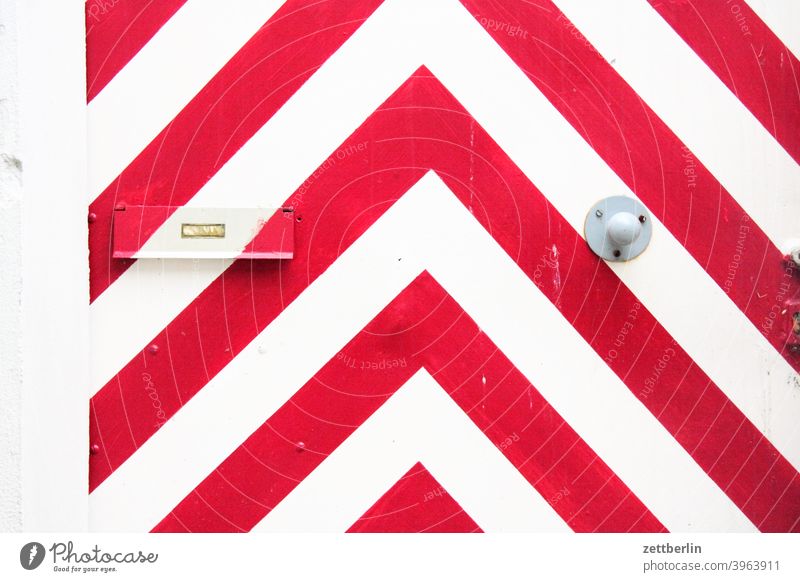 Rot-weiße Winkel auf einer Tür rot rotweiß winkel deko dekoration schmuck grafik tür wohnungstür eingang zugang briefkasten briefkastenklappe adresse zustellung