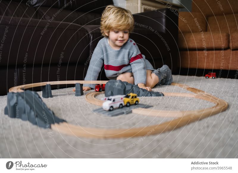 Kleiner Junge spielt mit Spielzeugbahn Kind spielen Straße Bahn zu Hause Aktivität wenig Kindheit Lifestyle Vorschule Freizeit kreativ Kinderbetreuung errichten