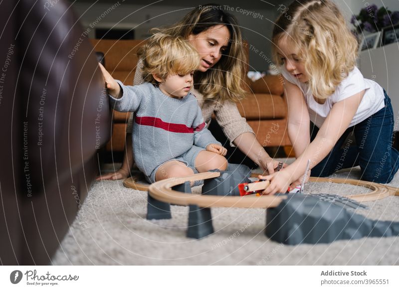 Mutter mit Kindern spielen mit Spielzeug Fahrbahn Zusammensein Straße PKW zu Hause Aktivität Eltern Lifestyle Liebe Kindheit Partnerschaft Mutterschaft