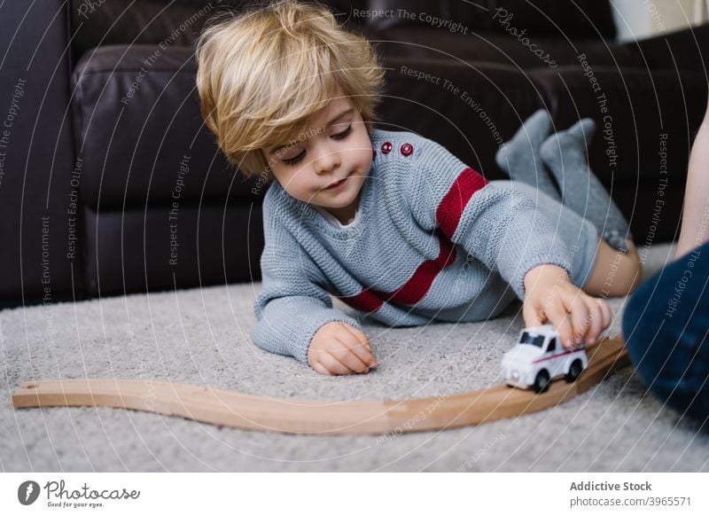 Glückliches Kind spielt mit Spielzeug zu Hause spielen Junge PKW Aktivität niedlich wenig Lügen Kindheit Lifestyle Vorschule Freizeit Kinderbetreuung genießen