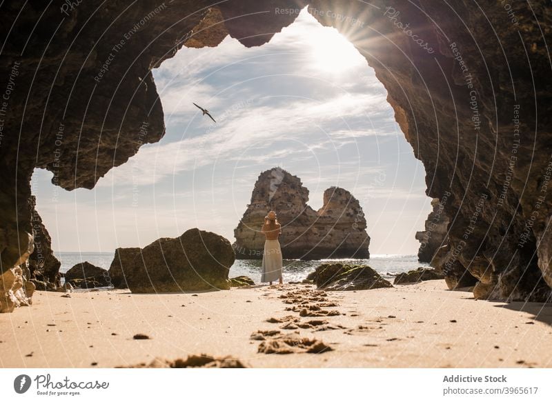 Anonyme Frau in Höhle am Meer MEER Ufer Natur Sand Eingang romantisch Urlaub Algarve Portugal reisen Strand Küste sich[Akk] entspannen Hut lässig Ausflug