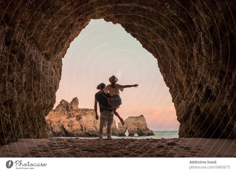 Anonymes Paar beim Heben im Höhleneingang Kuss Umarmung MEER Liebe Eingang Abend Mann Frau Algarve Portugal Umarmen romantisch Partnerschaft Meer Zusammensein