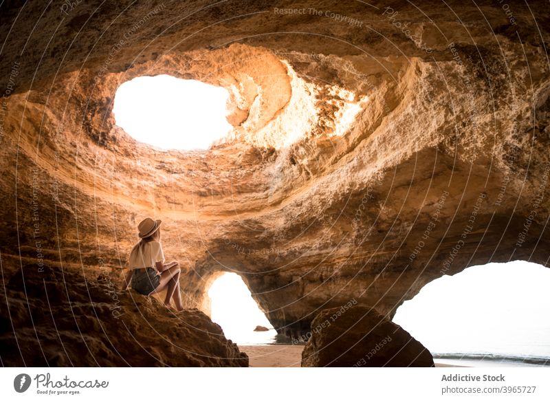 Unerkennbare Frau bewundert Höhle in der Nähe von Meer MEER bewundern Urlaub Zimmerdecke Golfloch sonnig tagsüber reisen Algarve Portugal Hut lässig idyllisch