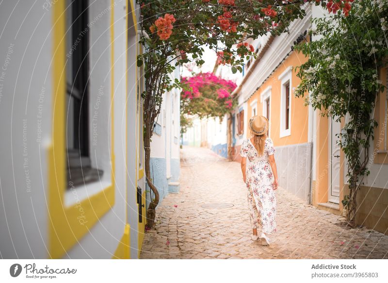 Gesichtslose elegante Dame waling auf der Straße in der Nähe von gemütlichen bunten Häusern während der Ferien in Portugal Frau Spaziergang Haus Revier erkunden