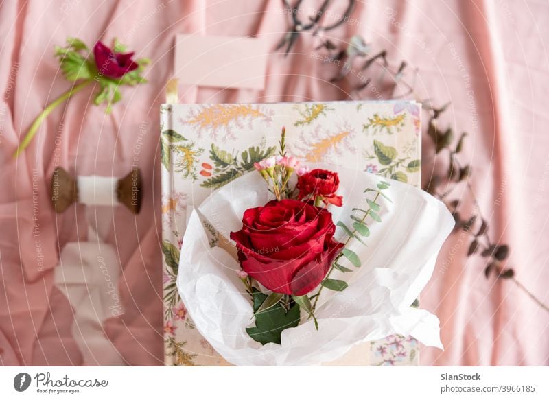 Kleiner Blumenstrauß aus roten Rosen, Ansicht von oben weiß Papier Roséwein Pastell Hintergrund vereinzelt Valentinsgruß Tag rosa grün Frühling geblümt Sommer