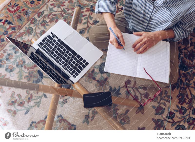 Senioren im mittleren Alter arbeiten zu Hause am modernen Laptop Smartphone Elektronik Mobile pc Textfreiraum Draufsicht flache Verlegung zuschauen