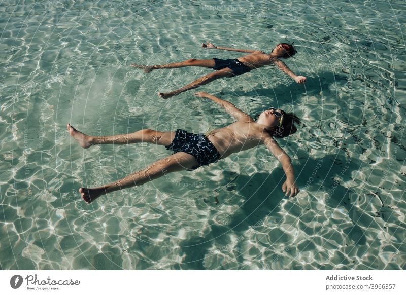 Zwei Jungen entspannt am Strand im Sommer Kind aussruhen MEER Wasser aqua Strandkinder blau Kaukasier Kindheit genießen Europäer Schutzbrille Fröhlichkeit Glück