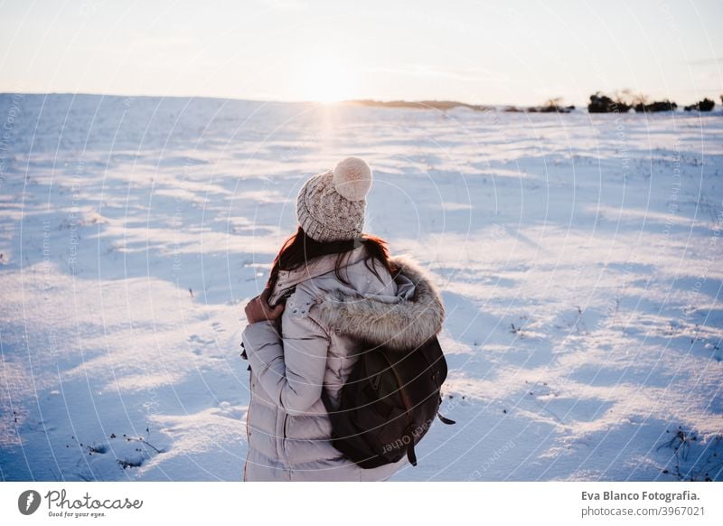 Rückenansicht der Frau in verschneiten Berg trägt modernen Mantel bei Sonnenuntergang. Wintersaison. Natur Rückansicht Schnee Berge u. Gebirge wandern kalt