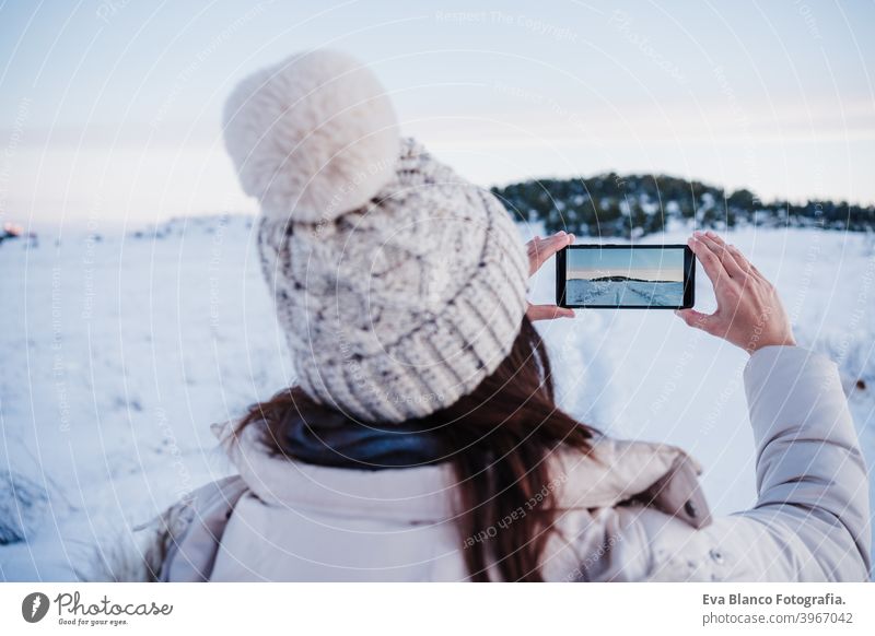 Rückenansicht von Backpacker Frau Wandern in verschneiten Berg ein Bild der Landschaft mit mobile phone.winter season. Natur und Technik Handy