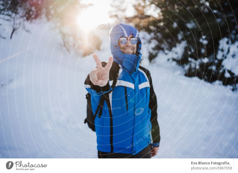 glücklich gut aussehend Mann in verschneiten Berg bei Sonnenuntergang. Reisen und Sport im Freien Konzept. Wintersaison Schnee Berge u. Gebirge wandern kalt