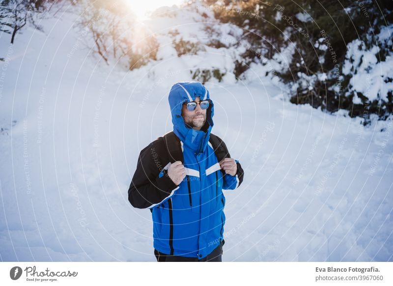 glücklich gut aussehend Mann in verschneiten Berg bei Sonnenuntergang. Reisen und Sport im Freien Konzept. Wintersaison Schnee Berge u. Gebirge wandern kalt