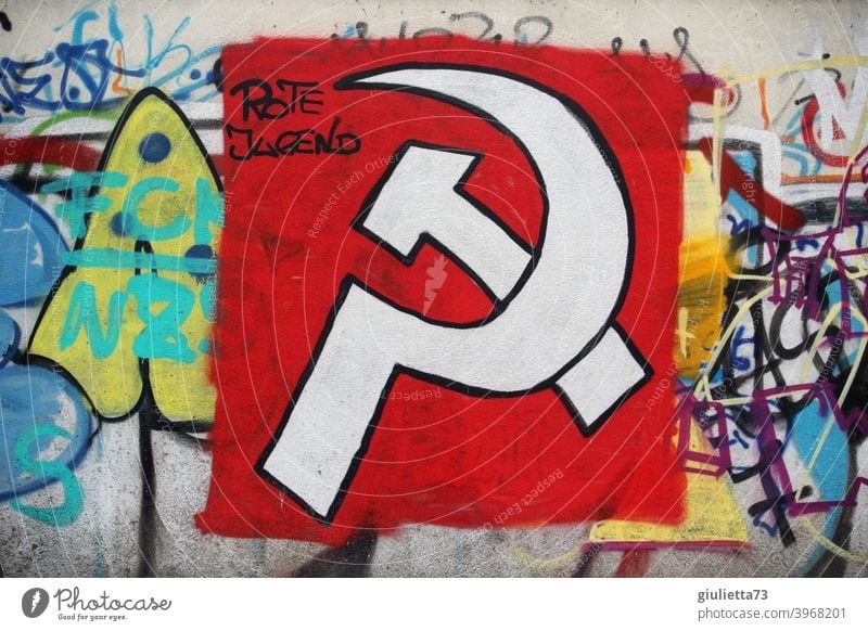 Graffiti | Hammer und Sichel mit weißer Farbe auf rotem Untergrund an eine Mauer gesprüht und mit den Worten Rote Jugend ergänzt grafitti Grafische Darstellung