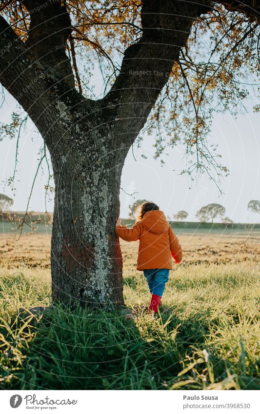 Rückansicht Kind in der Nähe eines Baumes unkenntlich Spielen Mädchen Natur Fröhlichkeit Farbfoto Tag Mensch niedlich Lifestyle Freizeit & Hobby Kleinkind Glück