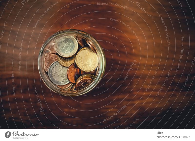 Ein Glas voller gesparter Geldmünzen sparen Hand Vogelperspektive Spardose Euro Bargeld Münzen Kleinvieh Holz sparsam sammeln Kleingeld Finanzierung