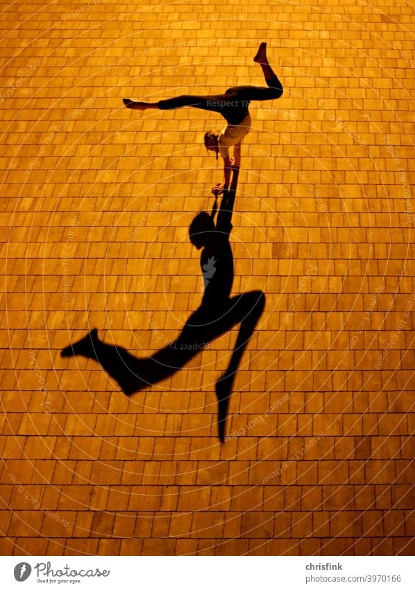 Turnerin bei Nacht mit Schatten schatten Licht Strukturen & Formen Kontrast Außenaufnahme Turnen Farbfoto handstand spagat contorsion bewegung