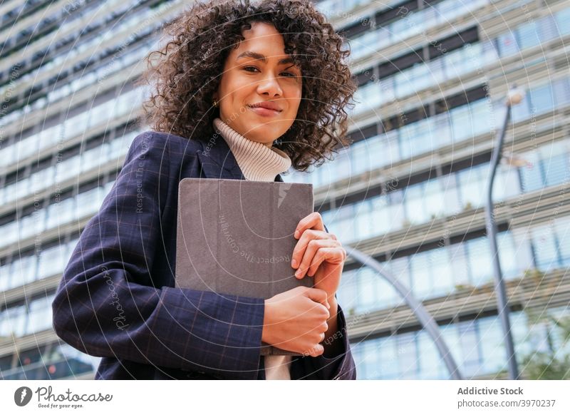 Geschäftsfrau hält Tablette auf Stadt Straße benutzend urban jung formal Browsen digital Zeitgenosse positiv ethnisch Frau krause Haare modern Lifestyle