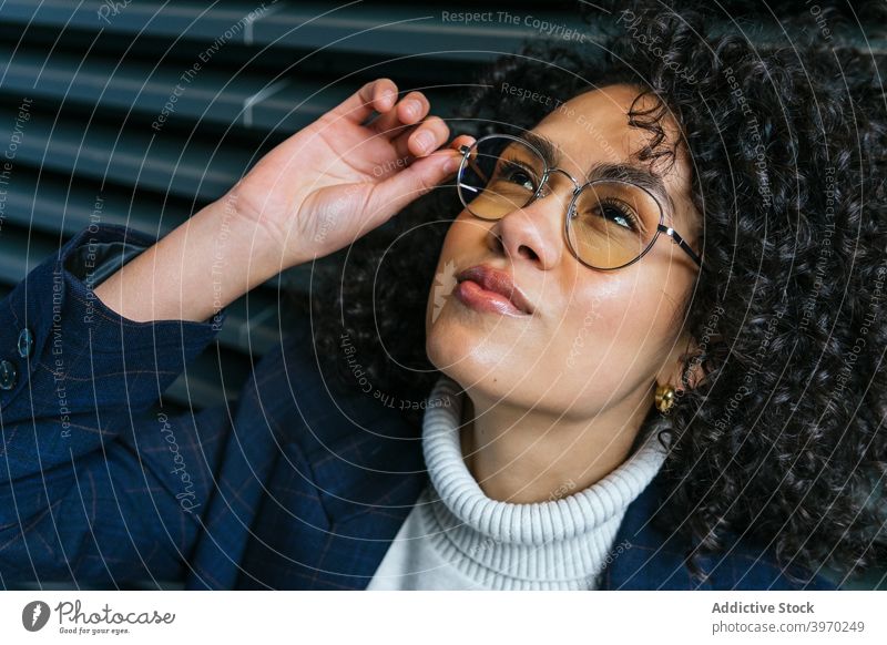 Selbstbewusste ethnische Geschäftsfrau mit Brille selbstbewusst selbstsicher Stil trendy ernst Mode jung Frau Spektakel Persönlichkeit berühren ausrichten