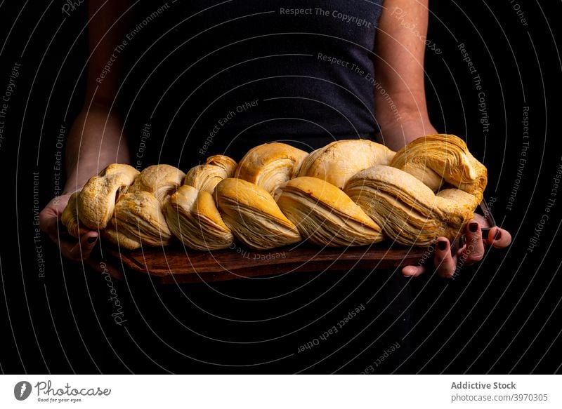 Frau mit handwerklich geflochtenem Brot Brotlaib Hauch Bäcker Geflecht Holzplatte Bäckerei Brötchen dunkel lecker Küche Kruste geschmackvoll Koch organisch