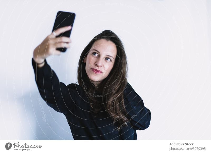 Lächelnde junge Frau nimmt Selfie auf Smartphone Telefon positiv teilen fotografieren Mobile Gerät Apparatur Lifestyle benutzend Selbstportrait Funktelefon