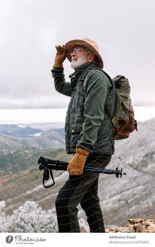Fröhlicher älterer Reisender in den Bergen Senior Mann Berge u. Gebirge Trekking Mast erkunden Winter Hochland Wanderung männlich Extremadura Cacere Spanien