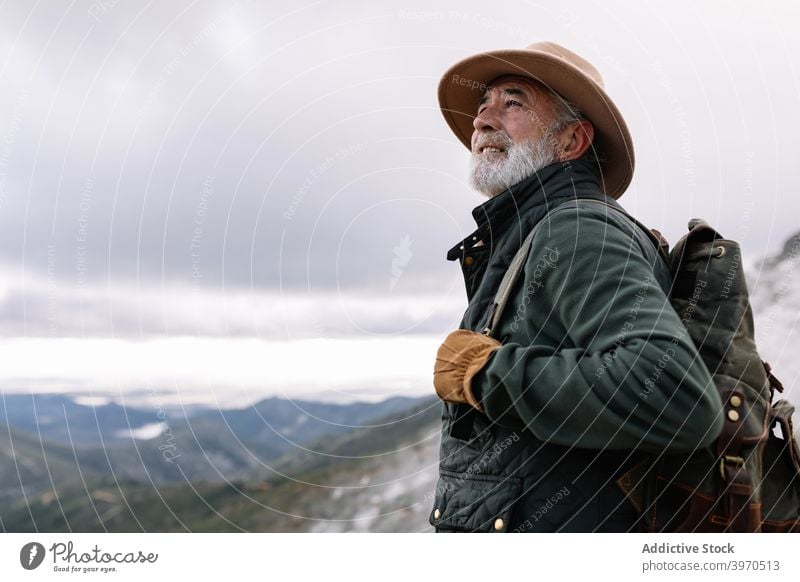 Senior-Reisender in den Bergen im Winter Mann Berge u. Gebirge erkunden bewundern Hochland Rucksack malerisch Cacere Spanien Extremadura Fernweh männlich älter