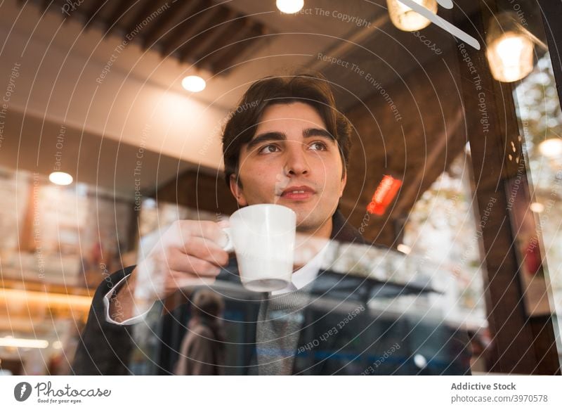 Junger Mann trinkt Kaffee im Cafe Café trinken genießen Fenster jung Tasse ruhen Pause positiv männlich gemütlich Lifestyle Getränk Heißgetränk Lächeln Freizeit