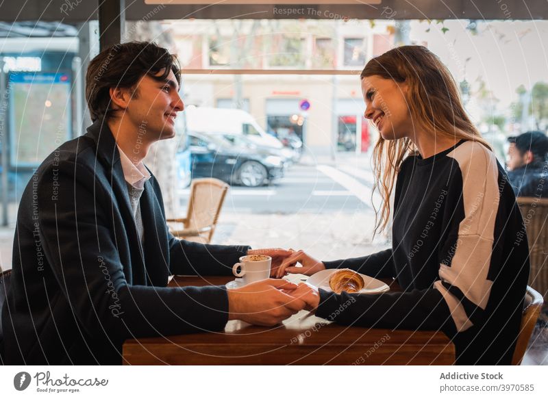 Glückliches Paar mit Datum in Cafe Café Liebe Zusammensein romantisch Termin & Datum Zuneigung jung Fenster Partnerschaft positiv heiter Händchenhalten