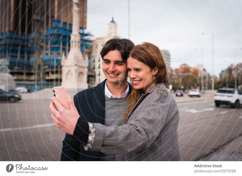 Verliebtes junges Paar nimmt Selfie auf der Straße Liebe Zusammensein Glück Smartphone Partnerschaft Umarmen Freundin heiter Lifestyle romantisch Zuneigung