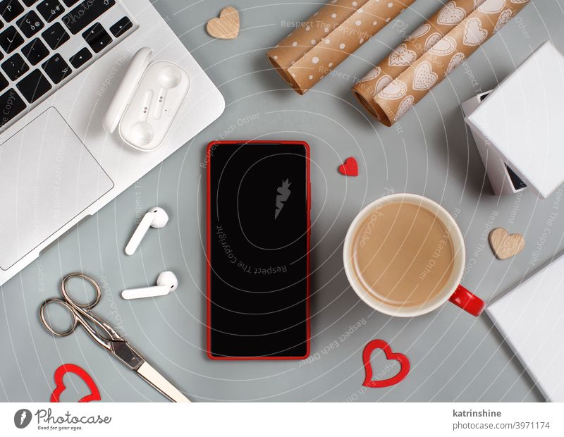 Red Handy und Tasse Kaffee in der Nähe von Laptop. Valentinstag Konzept Verpackung Valentinsgruß Tag Geschenk Attrappe klug arbeiten heimwärts Smartphone rot