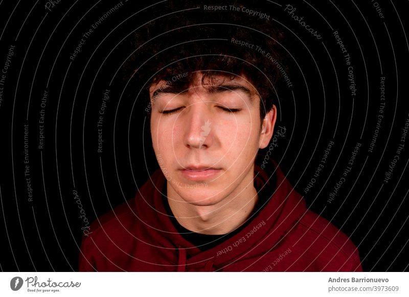 Attraktiver junger Mann mit lockigem Haar posiert auf schwarzem Studio Hintergrund Kaukasier Nahaufnahme nachdenklich Typ Blick Menschen kurz attraktiv