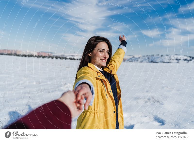 glückliche junge Frau hält Hände mit Kamera. Schnee Berglandschaft. Folgen Sie mir. Liebe und Lebensstil in der Natur Berge u. Gebirge Beteiligung Freund